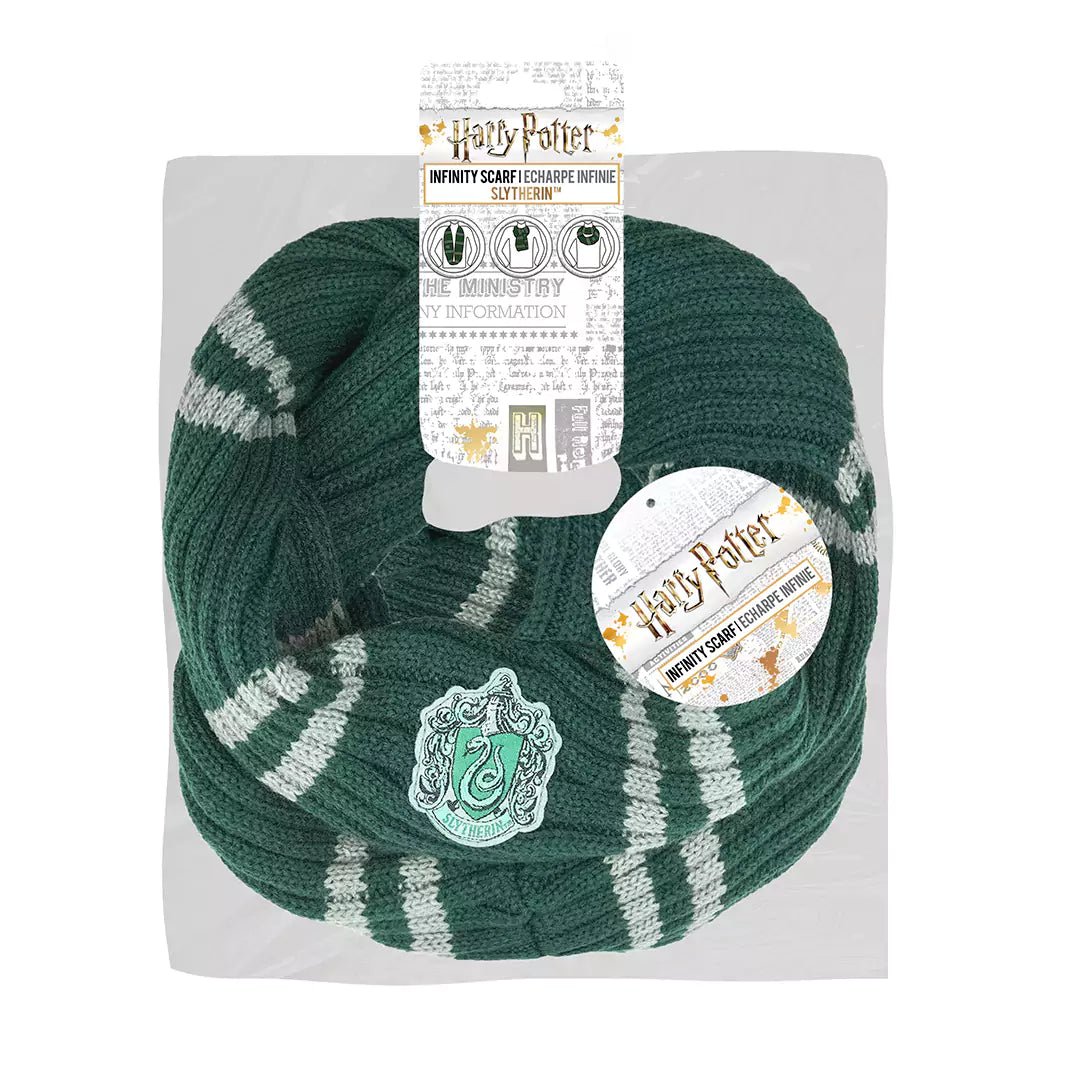 Donkergroene gebreide Zwadderich-infinitysjaal met lichtgrijze strepen en een opgenaaid wapen met slang. De sjaal ligt in lussen op een lichtgrijze kaart met Harry Potter-labels, tegen een witte achtergrond.