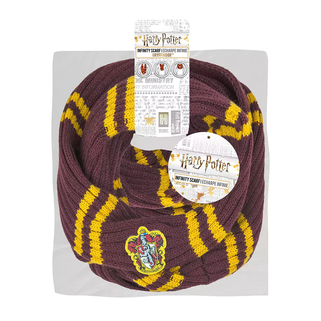 Bordeauxrode, gebreide Griffoendor-infinitysjaal met gele strepen en een geborduurd wapenschild, in lussen gevouwen op een lichtgrijze kaart. Harry Potter-labels hangen aan de sjaal tegen een witte achtergrond.
