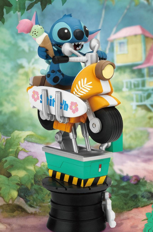 PVC-diorama van de blauwe Stitch, zittend met een ijsje op een oranje scooter met witte surfplank. De scooter staat als muntjesattractie op een groen-zwarte sokkel, tegen een onscherpe achtergrond met planten en een huis.