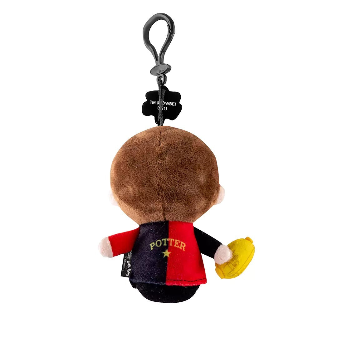 Achterkant van de Harry Potter-knuffelsleutelhanger: bruin haar en een rood-zwart Triwizard-shirt met de naam Potter en een gouden ster.