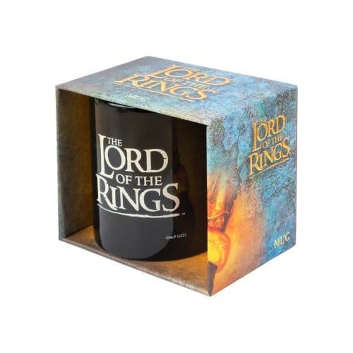 Zwarte mok met wit The Lord of the Rings-logo in een blauwgroene kartonnen doos met goudgele letters en een oranje vuurmotief. De doos staat schuin op een witte achtergrond en is aan de voorkant open.
