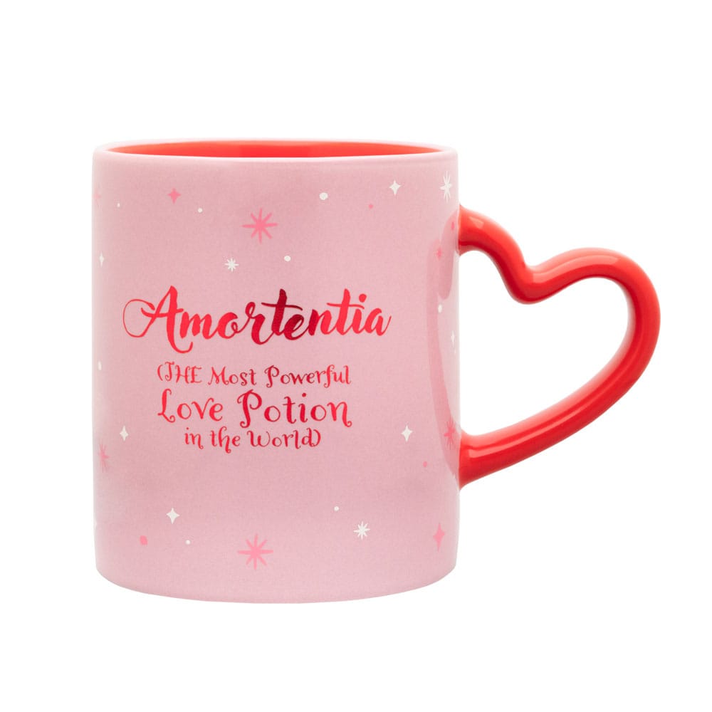 Lichtroze keramische mok met rode binnenkant en rood hartvormig oor rechts, rechtop tegen een witte achtergrond. Op de mok staan roze en witte sterretjes en de rode tekst ‘Amortentia – The Most Powerful Love Potion in the World’.