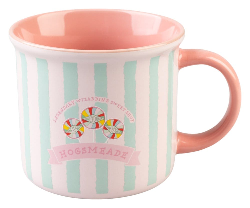 Glanzende keramische Honeydukes-mok met mintgroene en lichtroze verticale strepen, roze binnenkant en oor rechts. Vooraan staan drie gekleurde lolly’s en de tekst ‘Hogsmeade’; de mok staat tegen een witte achtergrond.