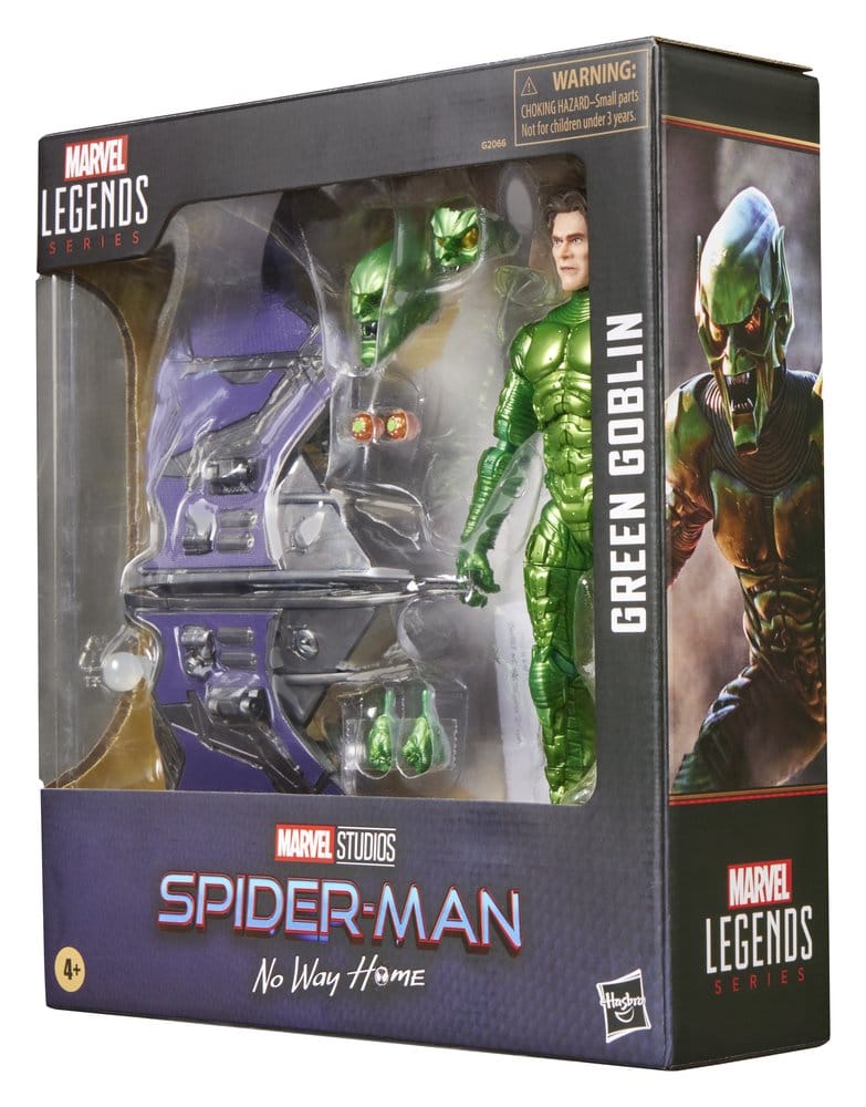 Green Goblin-actiefiguur van kunststof in glanzend groen harnas, rechtop in een zwarte doos met transparant venster. Ernaast liggen een paars-zilveren zweefvliegtuig, extra hoofden en handen; de achtergrond is wit.