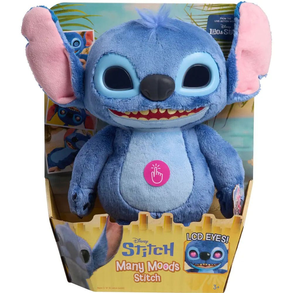 Blauwe pluchen Stitch met grote roze binnenoren, zwarte ogen en neus, een brede grijns en lichtblauwe buik met roze druksticker. Hij zit rechtop in een geel bedrukte kartonnen verpakking tegen een witte achtergrond.